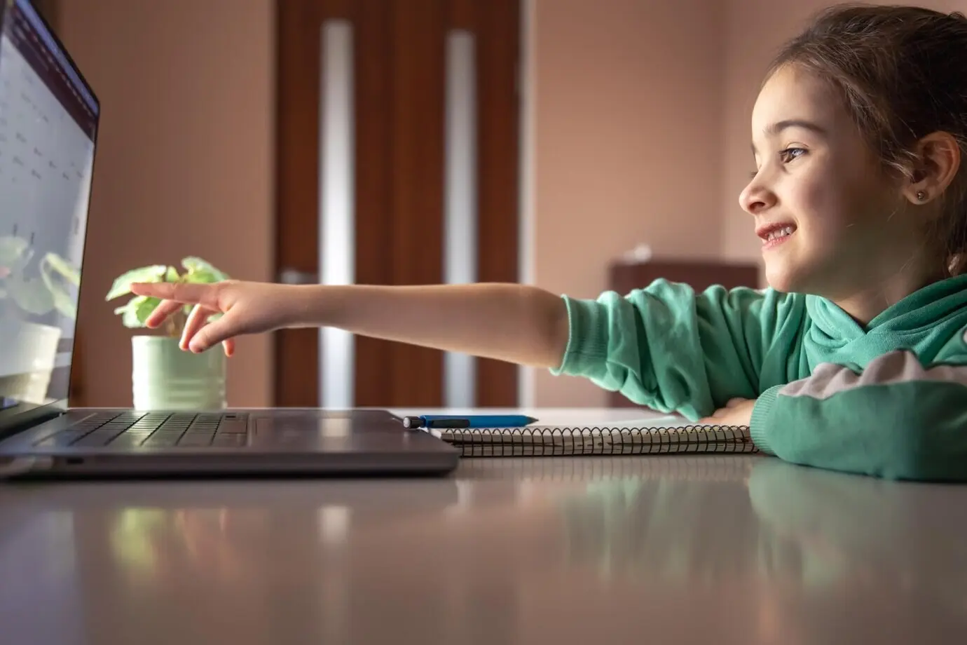 Kleines Mädchen vor einem Laptopbildschirm, Lernkonzept