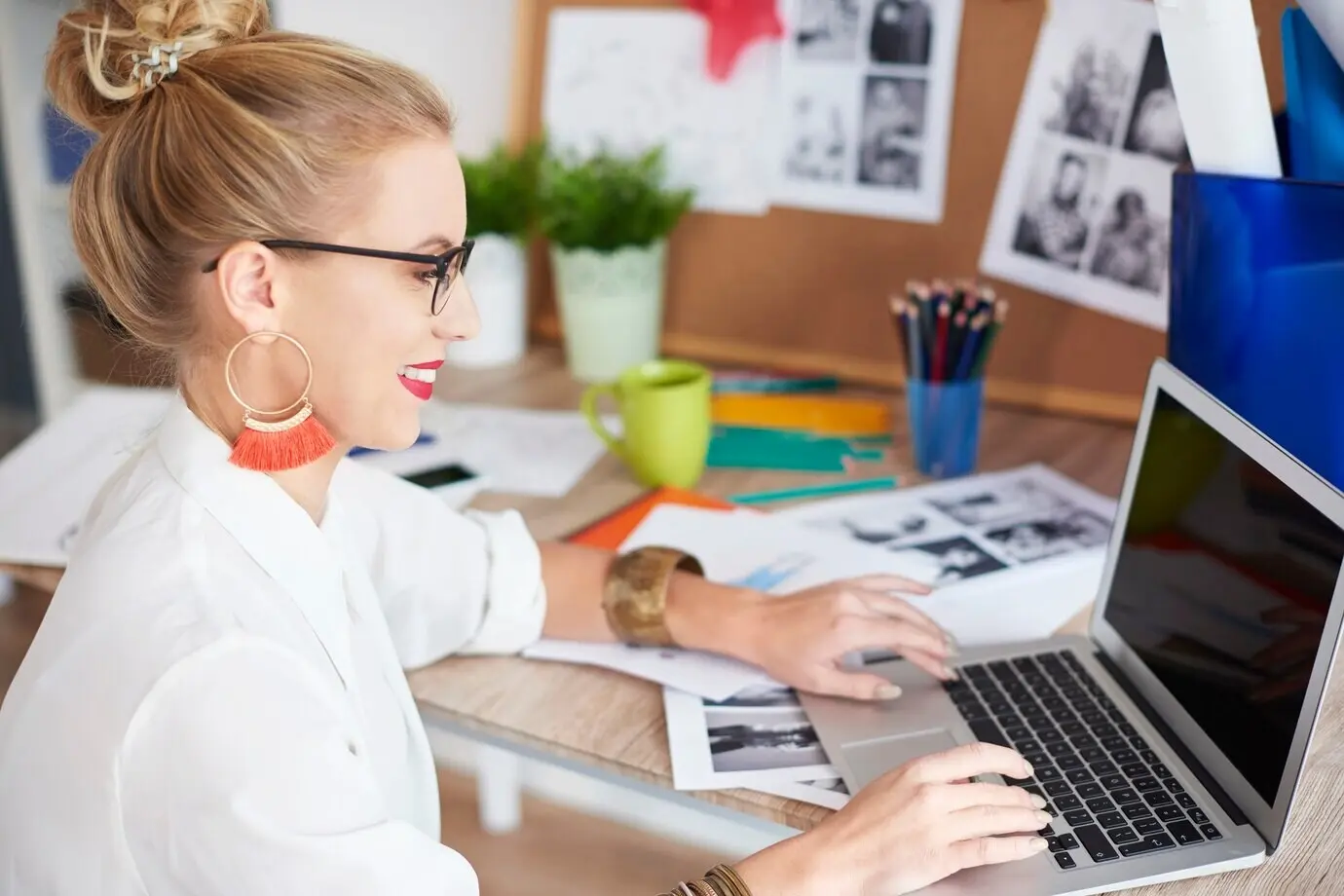 Seitliche Ansicht einer Frau, die zu Hause mit einem Laptop arbeitet.
