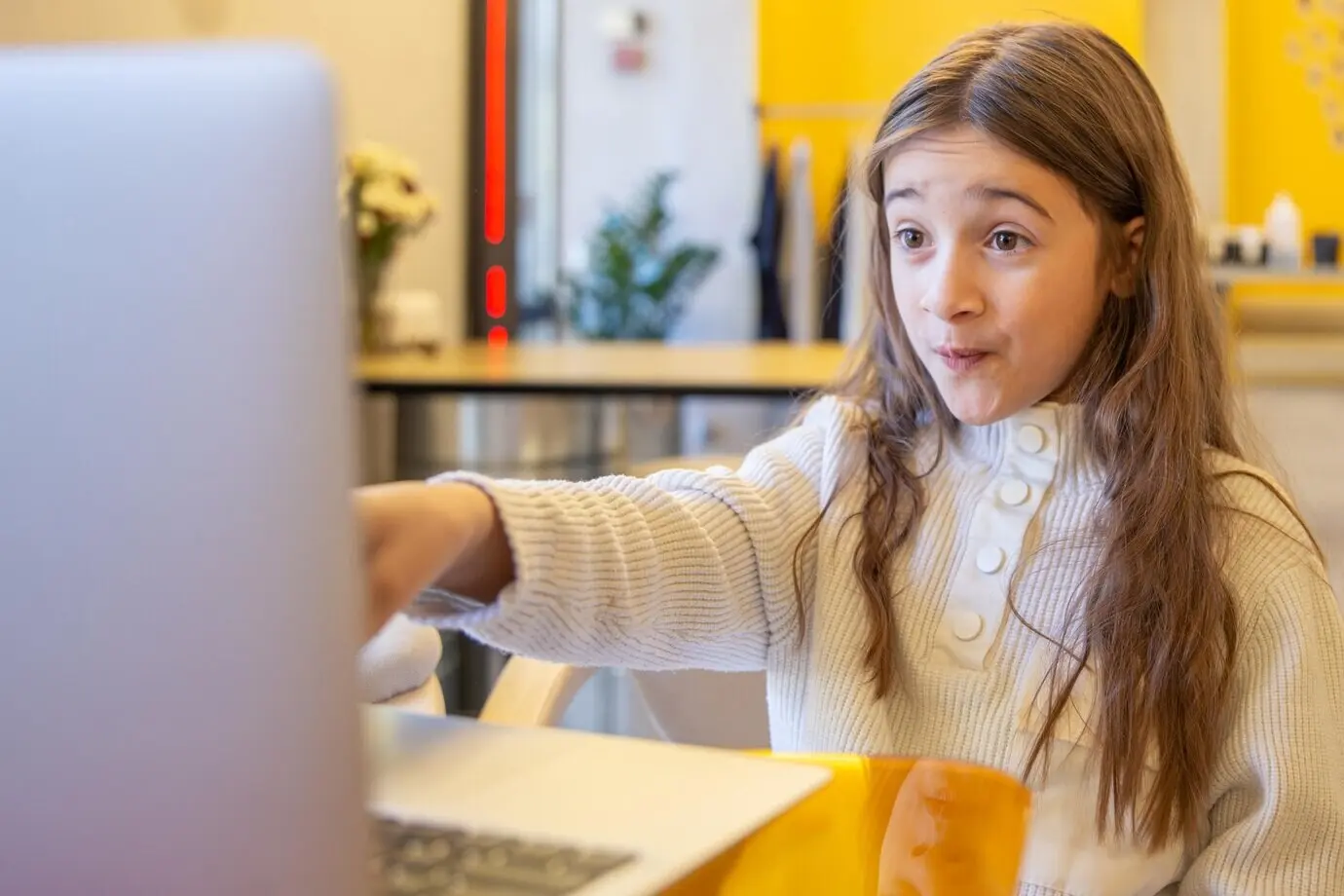 Überraschtes Mädchen mit Laptop; Technologie-Konzept: Mädchen und Laptop.